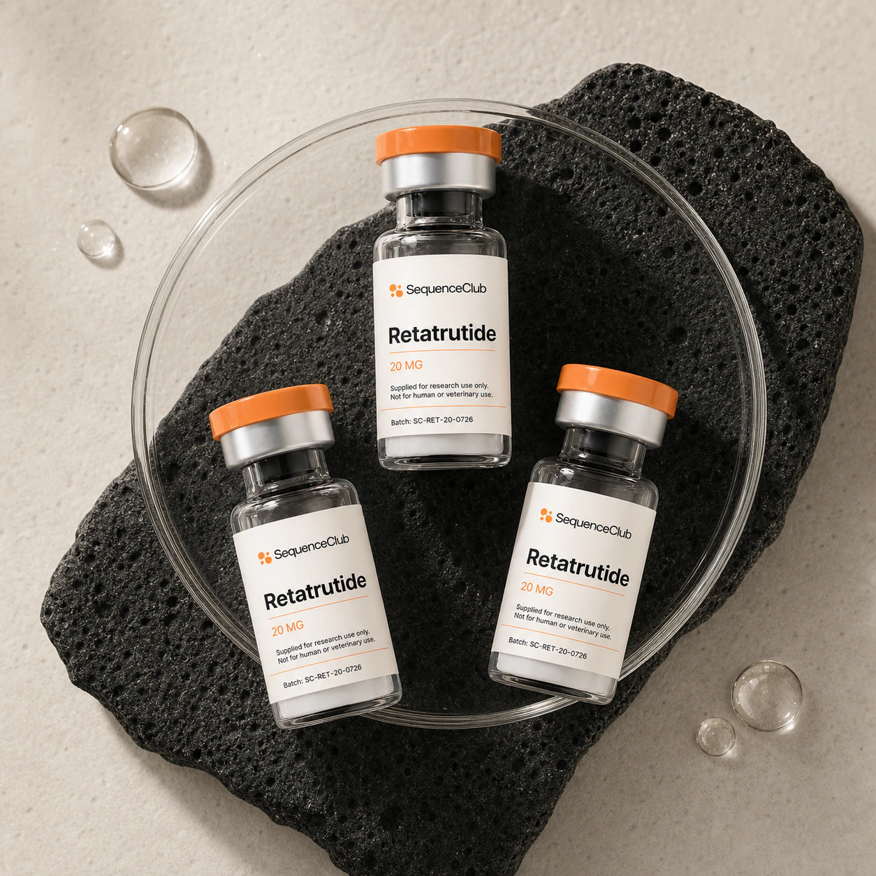Three Retatrutide 20 mg research vials arranged in a clear sample dish with volcanic stone.